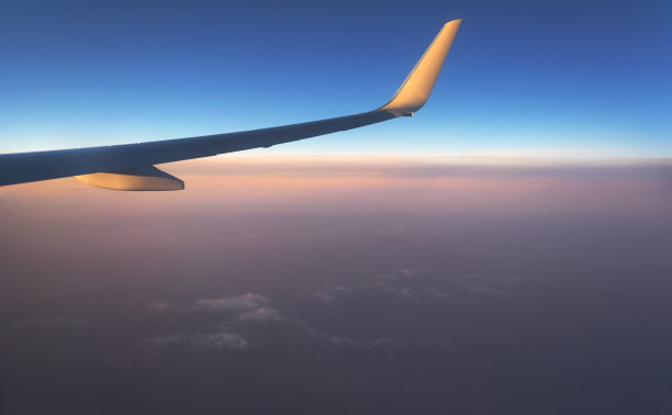 从飞机的窗口观看地平线上的湖泊和河流与森林在日落的一天被太阳光线图片下载