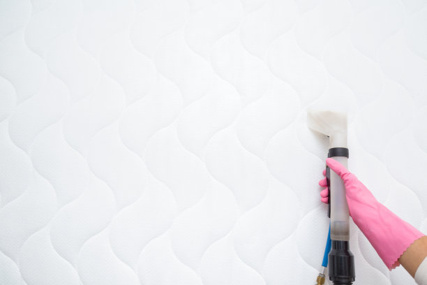 员工手戴防护手套，用专业的提取方法清洗床垫。定期清理。商业清洁公司。视角拍摄。副本的空间。文字或标识的空白位置。图片下载