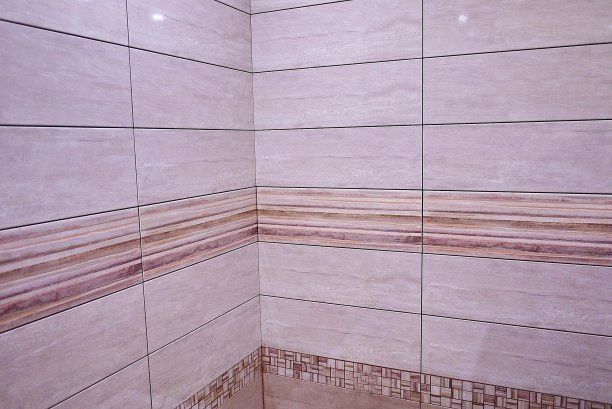 浴室内部用美丽的瓷砖装饰，有自然的风景。铸铁浴缸，淋浴，内置水槽和床头柜。图片下载