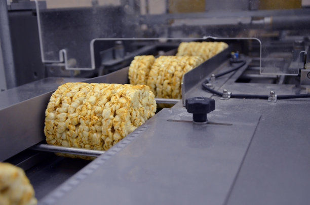 用于生产全谷物挤压脆面包的传送带自动胶带。在工厂包装有机多大麦团块脆面包图片下载