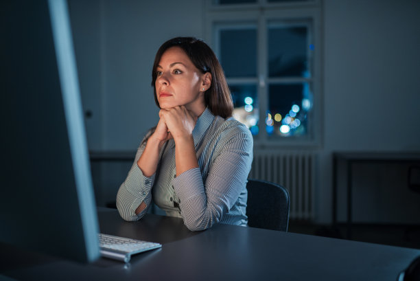 一个精疲力竭的女人加班工作的肖像。图片下载