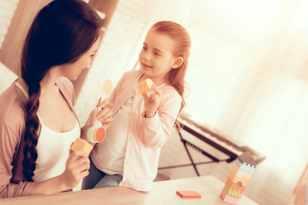 女人和女孩在公寓玩学习游戏。图片下载