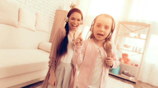 穿着睡衣的女孩和妈妈拿着梳子唱歌图片下载