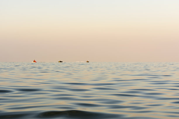 傍晚海面波涛汹涌，远处有一辆水平线上漂浮的水车，自然抽象的背景图片下载