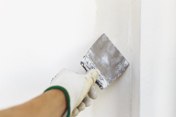 用铲子作画的油漆工。油灰抹子涂抹层的过程图片下载