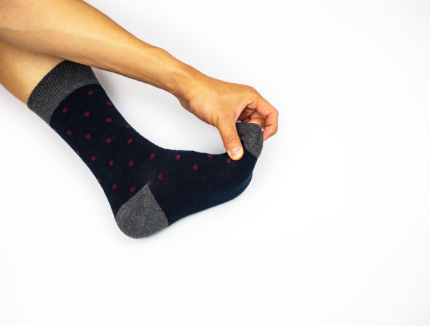 用手拉脚趾，穿着袜子在白色背景上按摩脚图片下载