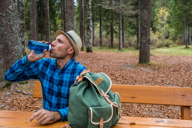 年轻的成年人肖像在森林里喝水图片下载