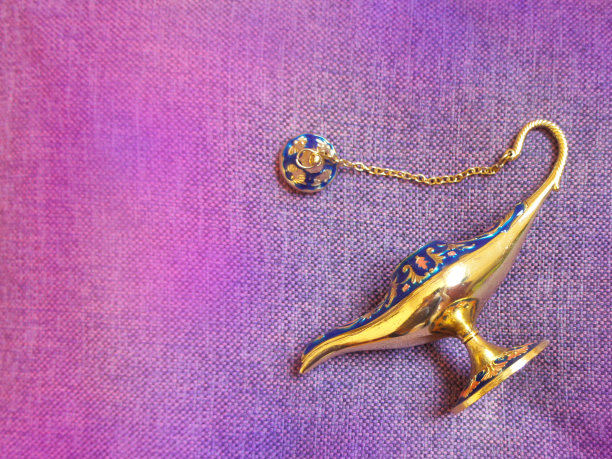 紫色织物上的神奇古董阿拉丁灯。关闭了。平的。图片下载