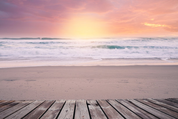 阳光明媚的早晨，沙滩上有木制栈道。热带度假胜地图片下载