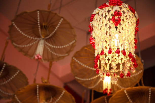 移动式花环吊顶吊灯以木质伞为背景装饰家具，家居室内建筑设计。传统灯光室内照明装饰理念图片下载