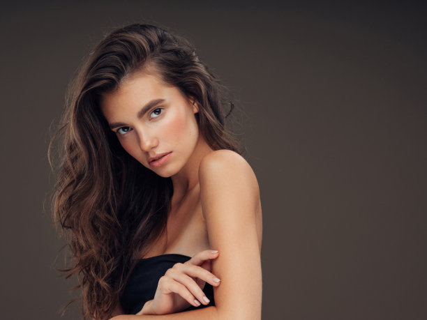 年轻美丽的模特长波浪整齐的头发图片下载