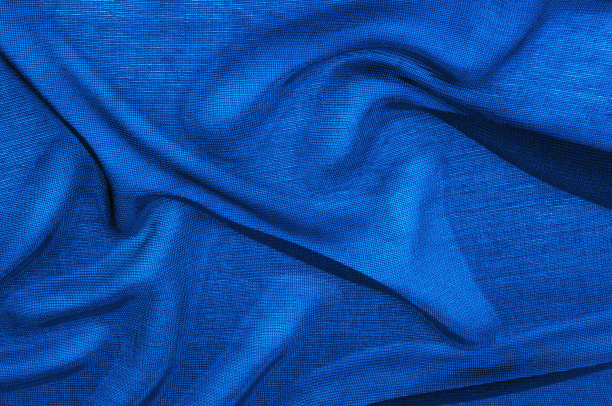 质地、背景、模式。蓝色透明的织物。与镜面欧根纱相比，水晶欧根纱有一种颗粒状的光泽和感觉，镜面欧根纱有更平滑的光泽/反射和感觉。图片下载