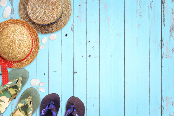 草帽和凉鞋在木制背景上。图片下载