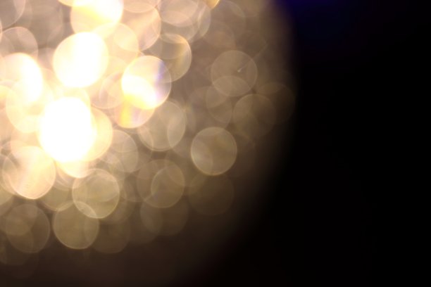 金色的散景模糊了黑色背景上的背景纹理图片下载