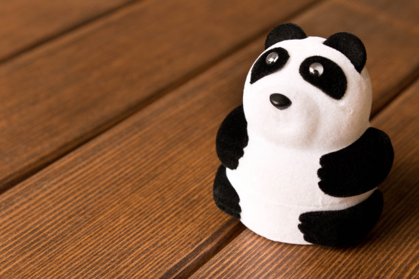 木头桌子上的有趣玩具熊猫。图片下载