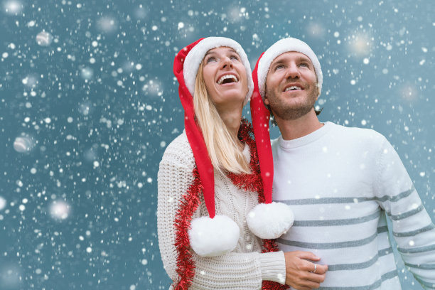 新婚夫妇戴着圣诞帽仰望天空为何下雪图片下载