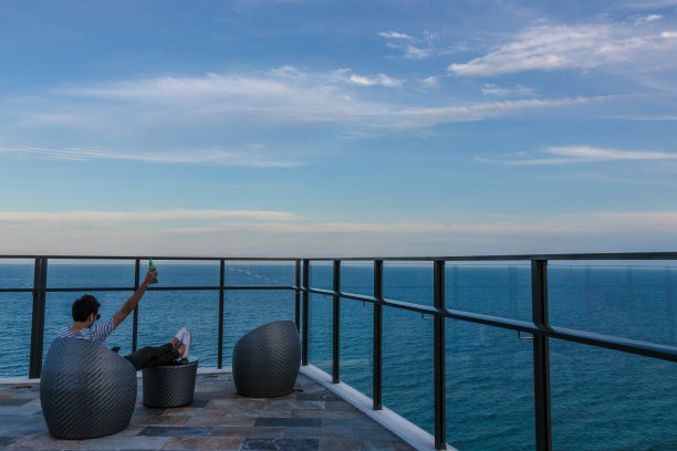 冰冷的游客在阳台上与海景图片下载