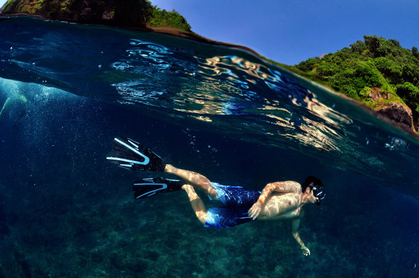 大海和天空就在一个快乐的潜水人之间。图片下载