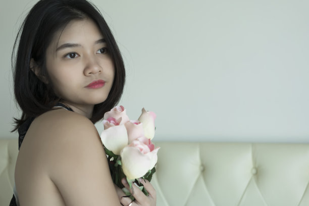 亚洲年轻漂亮的女人捧着一束玫瑰的肖像图片下载
