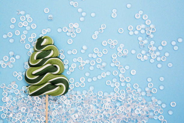 蓝色背景上的圣诞树棒棒糖。新年的照片。图片下载