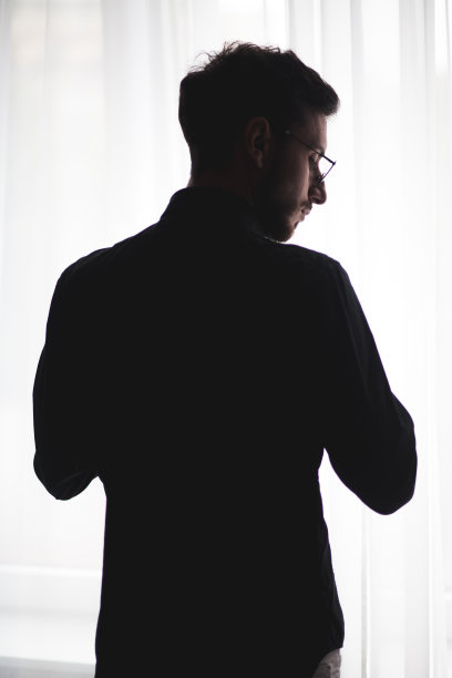 一个年轻人在酒店房间里的剪影图片下载