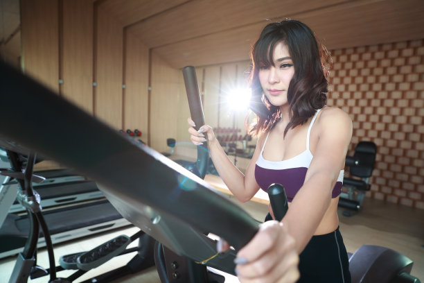 健康和运动的年轻女性在健身房使用锻炼机器的肖像(此图像用于健身和锻炼的概念)图片下载