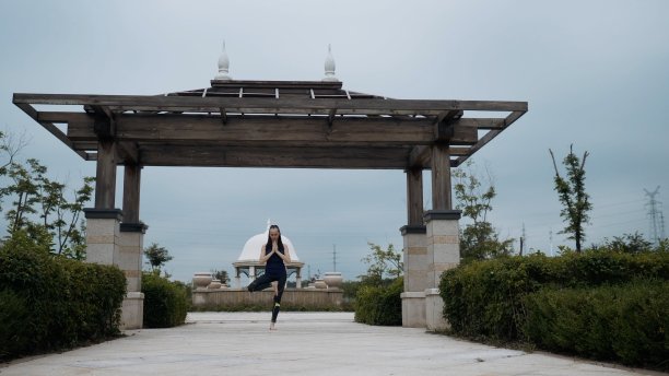 年轻的白人妇女在运动服装放松练习瑜伽在城市公园赤脚。日出的背景。慢动作图片下载