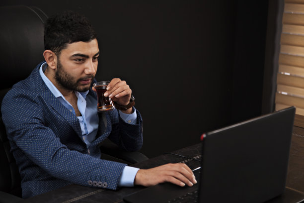 年轻的商人在办公室里用笔记本电脑工作图片下载