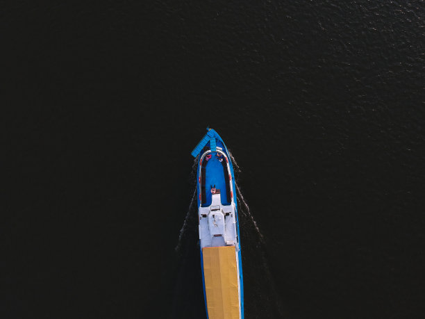 从河上漂浮的船的高度看，周围的森林图片下载