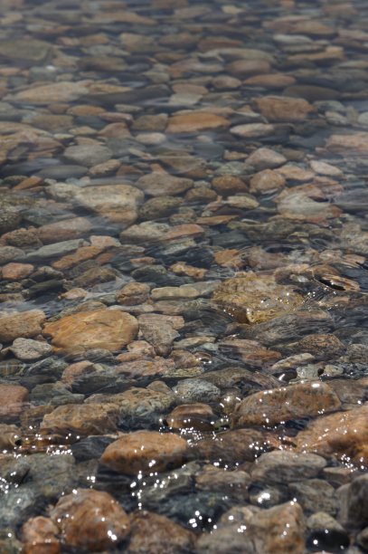 低角度的岩石和石头下流动的水在小溪图片下载