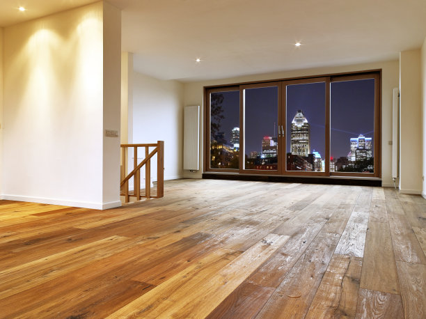 客厅内部与木地板和夜间城市灯光的看法图片下载