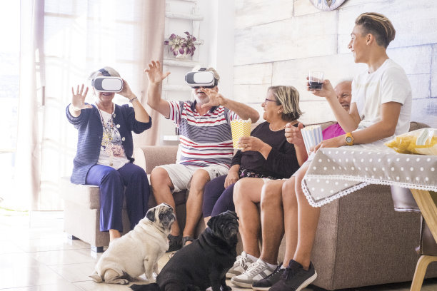 4个白发老人，一个小男孩和2只狗在客厅玩，花时间在一起聚会活动的家人在家里的友谊，有乐趣和欢笑。虚拟现实眼镜耳机技术图片下载