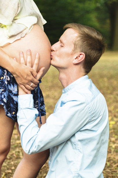 青年男子在户外亲吻孕妇的肚子图片下载