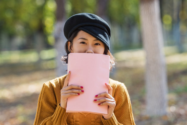 一个亚洲女孩在公园里看书图片下载