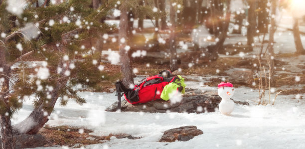 小雪人和背包的背景是不集中的树在下雪图片下载