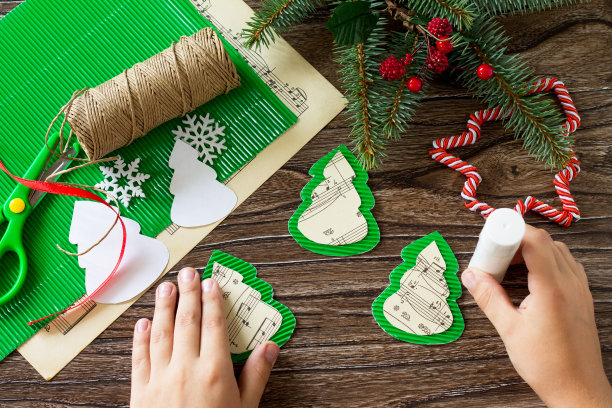 孩子把零件粘在圣诞玩具枞树上。手工制作的。儿童创意项目，手工艺品，儿童工艺品。图片下载