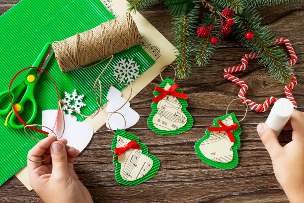 孩子把零件粘在圣诞玩具枞树上。手工制作的。儿童创意项目，手工艺品，儿童工艺品。图片下载