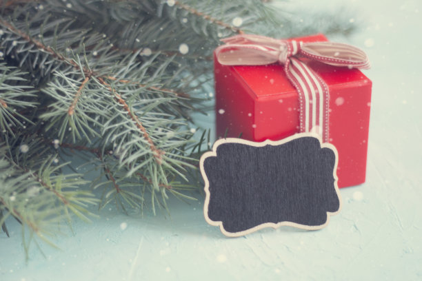 红色的圣诞礼盒和黑色的铭文板上的蓝色背景图片下载