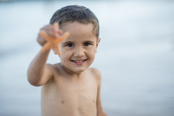 可爱的男孩找到了一只海星图片下载