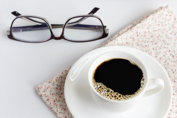 一杯白咖啡和玻璃杯放在亮粉色的布上。早上喝杯咖啡放松一下。图片下载