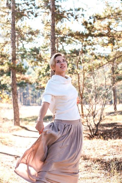 美丽的女人在森林里享受秋日。图片下载