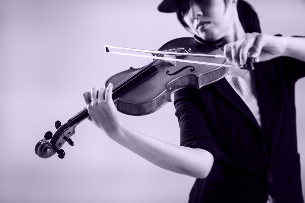 小提琴简洁的艺术设计背景是由女士演奏的，模糊的灯光设计背景图片下载