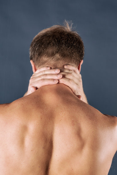 男子双手抱住脖子，孤立在蓝色背景下。降低颈部疼痛。赤裸上身的男人摸着脖子痛图片下载
