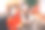 幸福的年轻人和女人坐在沙发上，拿着杯子和热饮的舒适图片。她看着镜头。他拥抱她，直视前方。他们是快乐的。图片下载