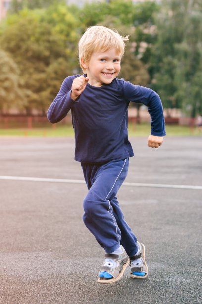 在一个现代城市积极的生活方式-快乐的小男孩跑过体育场图片下载
