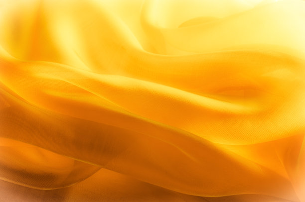 照片模糊了。质地、背景、模式。黄色丝绸织物。抽象的背景豪华蓝色织物或液体波或波浪垃圾纹理。整个背景。图片下载