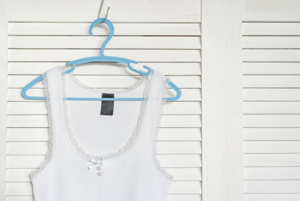衣架上的白色运动衫。背景上的白色百叶窗图片下载