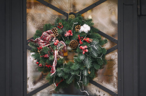 圣诞的雪花花环挂在玻璃门上。节日的象征图片下载