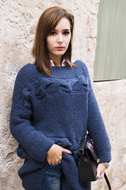 在旧城里，这位时尚的女士穿着手工编织的毛衣图片下载