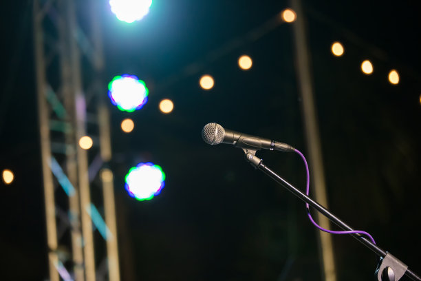 在音乐厅或会议室的麦克风柔和和模糊风格的背景。麦克风上方是会场或会议室背景的抽象模糊照片。图片下载